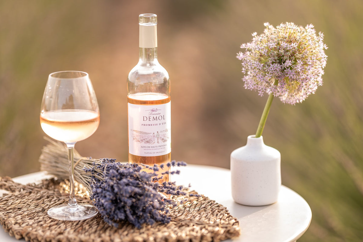 Vin rosé Promesse d'Été du Domaine Demol servi au verre, dans un décor de lavande de Provence