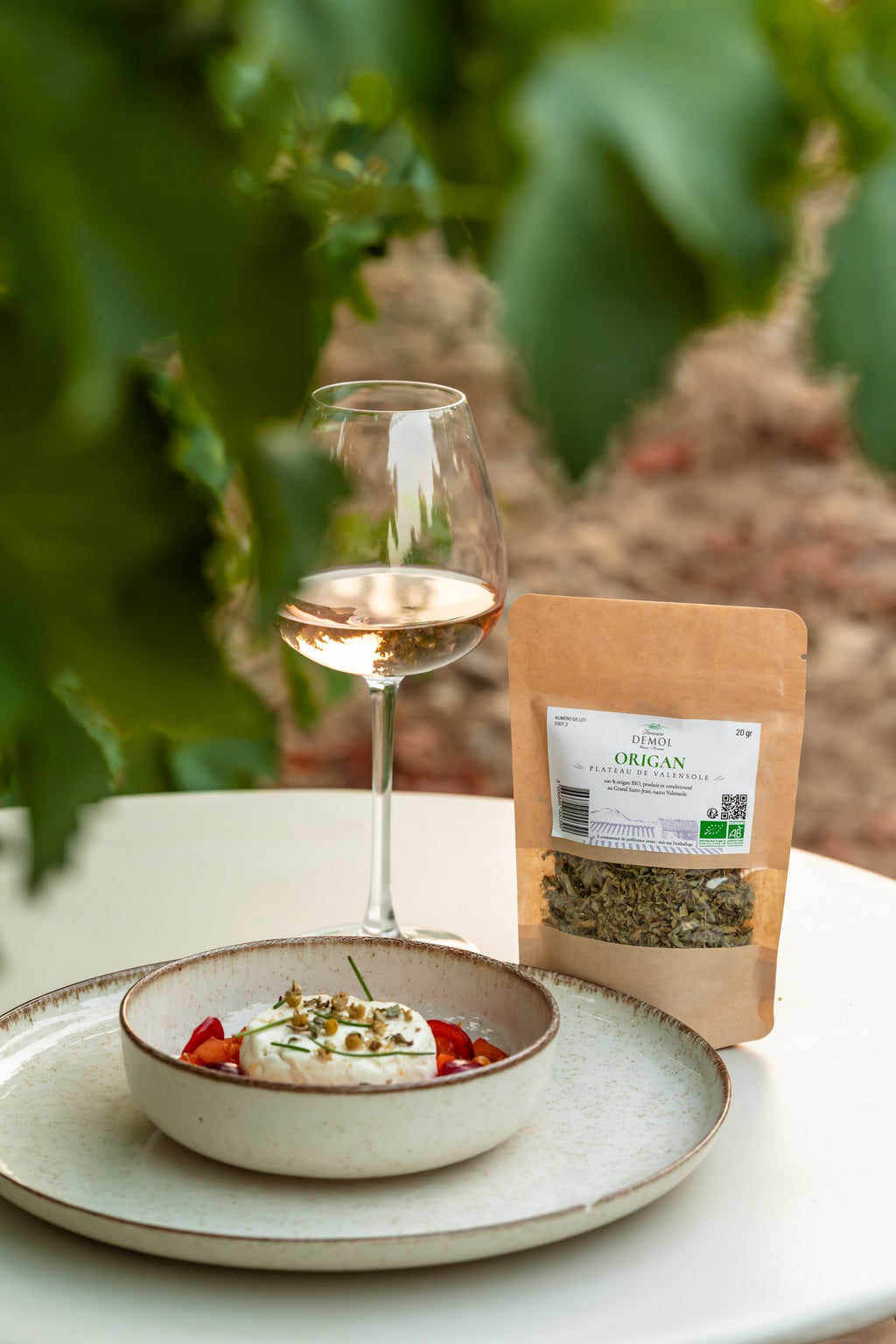 Origan BIO du Domaine Demol en sachet, accompagné d'un verre de vin blanc du domaine