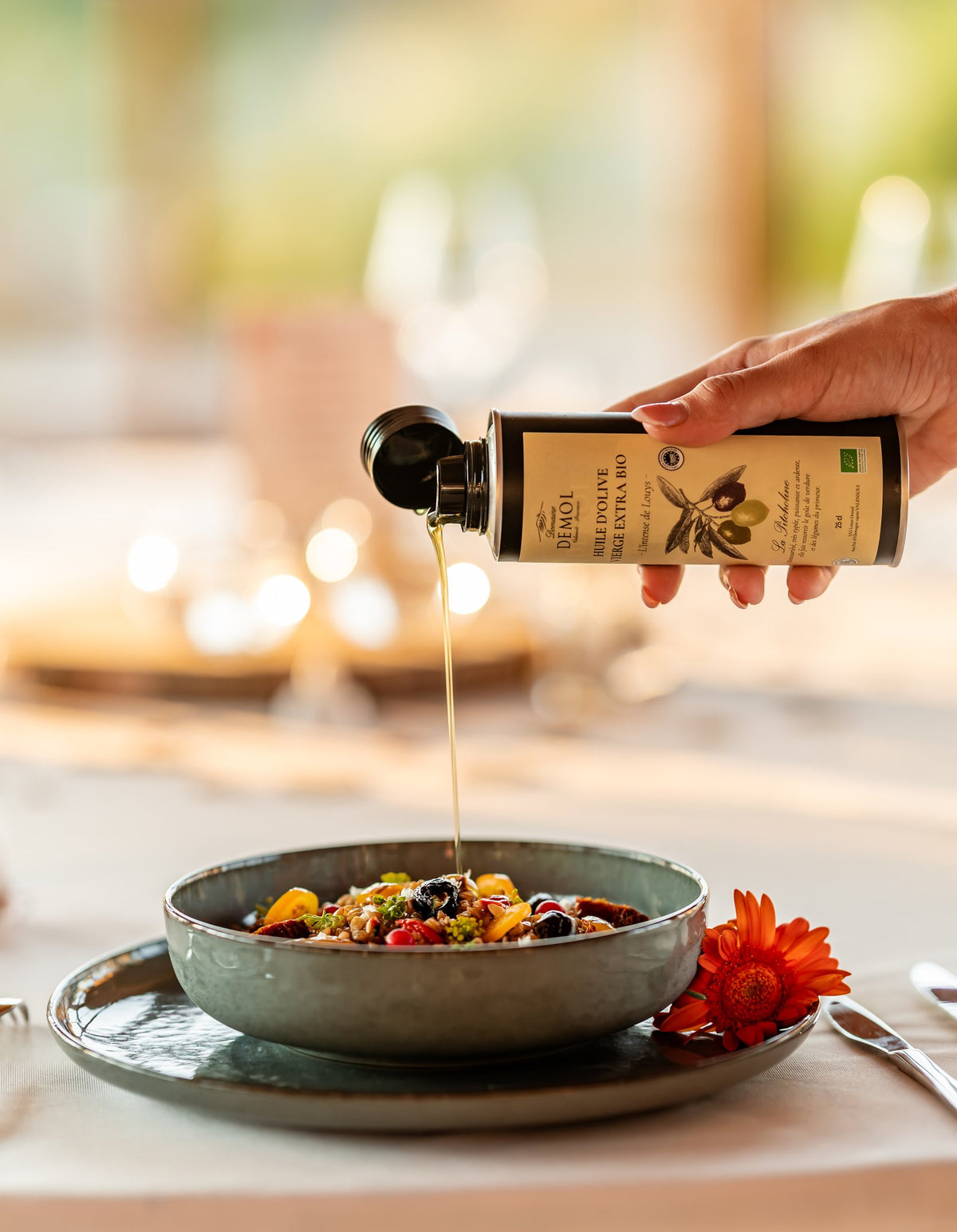 Filet d'huile d'olive 100 % Picholine BIO du Domaine Demol versé sur un plat de légumes du Sud