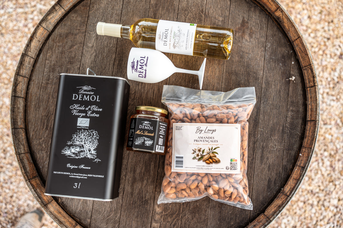 Coffret Signature Provence sur un tonneau : vin blanc, verre Demol, huile d'olive 3 l, miel et amandes