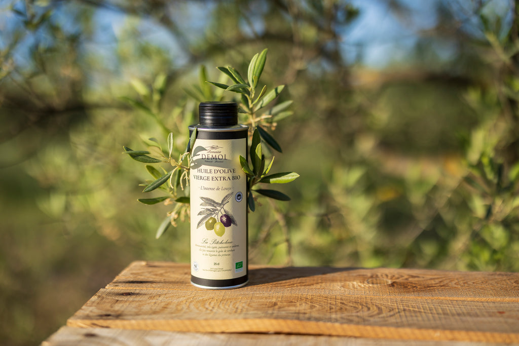 Bouteille de 25 cl d'huile d'olive 100 % Picholine BIO du Domaine Demol, posée sur une table en bois