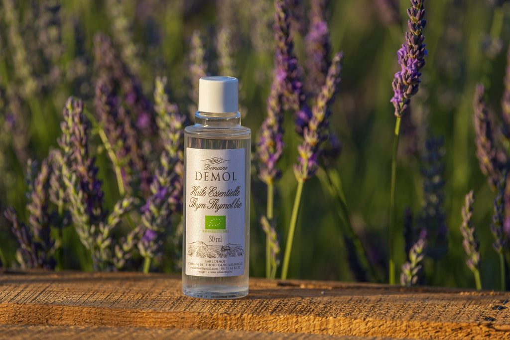 Flacon de 30 ml d'huile essentielle de thym à thymol BIO du Domaine Demol posé sur une planche de bois