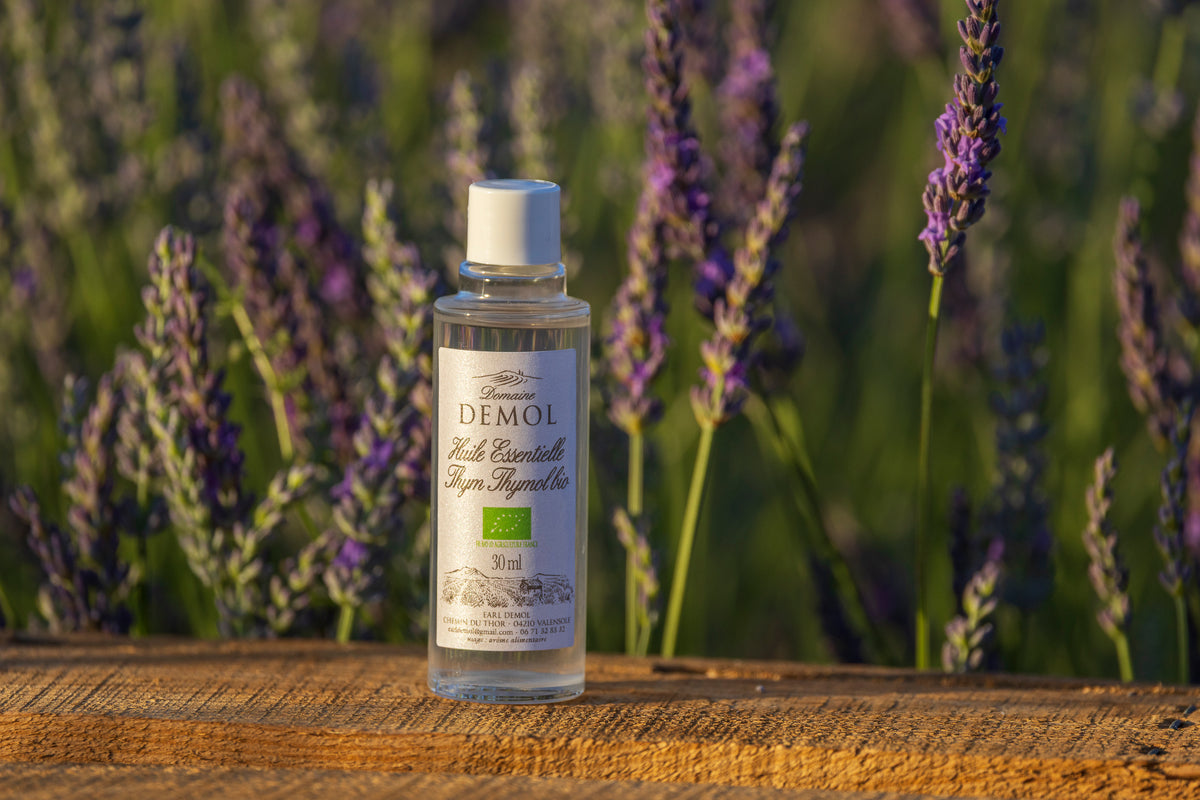Flacon de 30 ml d'huile essentielle de thym à thymol BIO du Domaine Demol posé sur une planche de bois