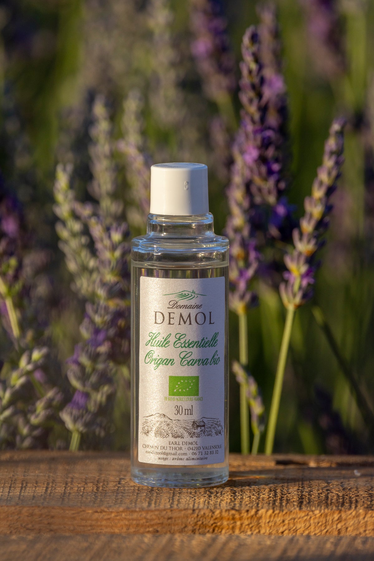 Flacon de 30 ml d'huile essentielle d'origan à carvacrol BIO du Domaine Demol, devant un champ de lavande