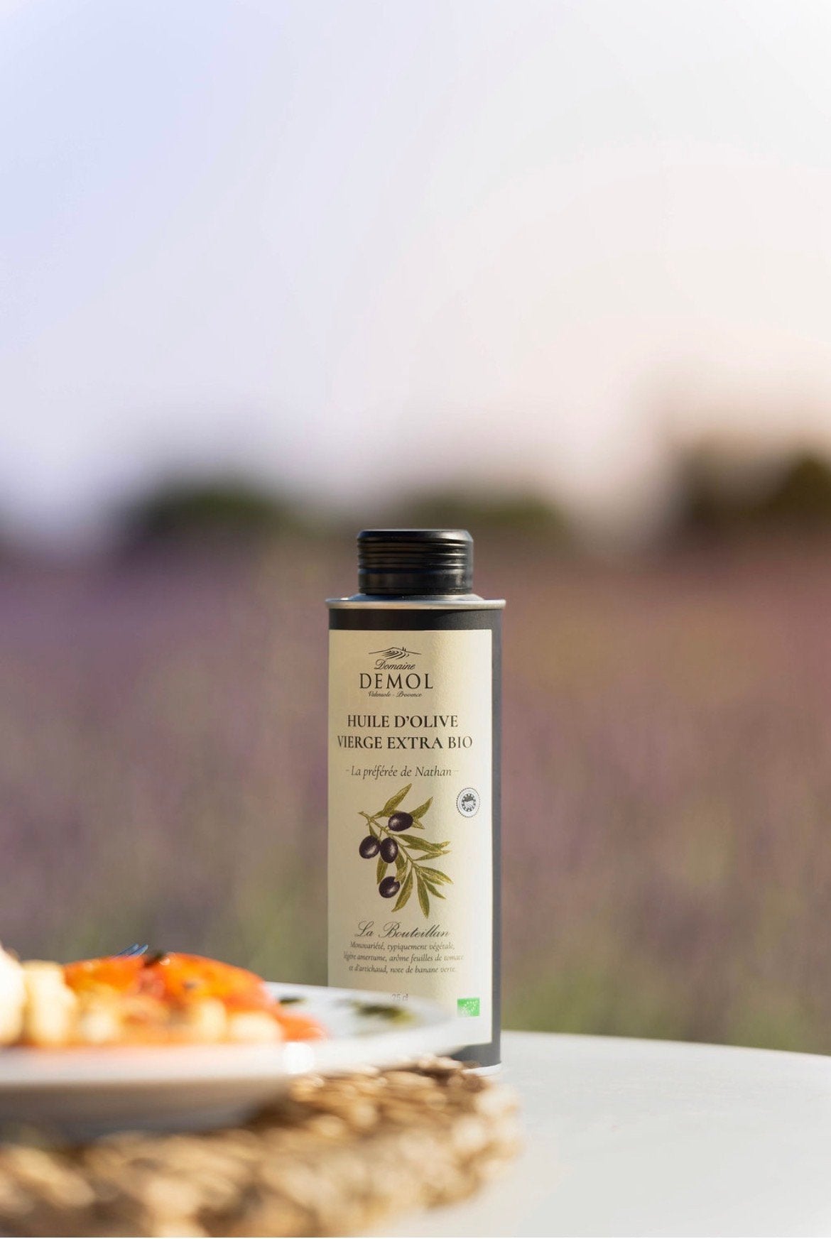 Bidon d'huile d'olive 100 % Bouteillan BIO du Domaine Demol devant un champ de lavande en fleur