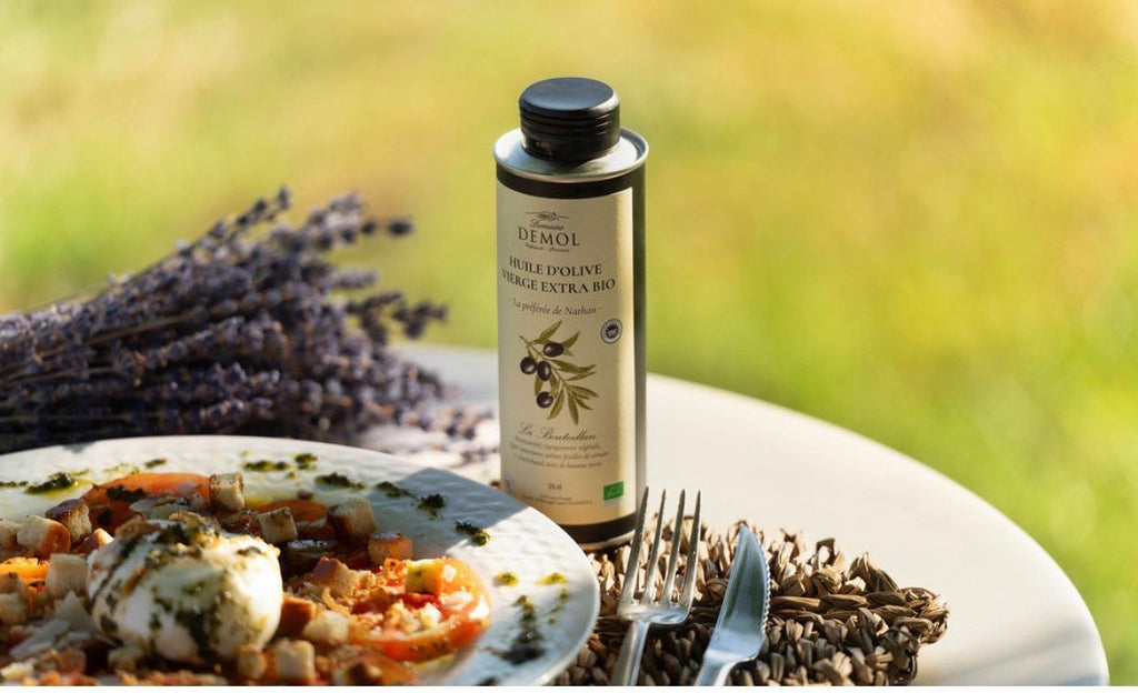Huile d'olive 100 % Bouteillan BIO du Domaine Demol et son assiette, devant un bouquet de lavande