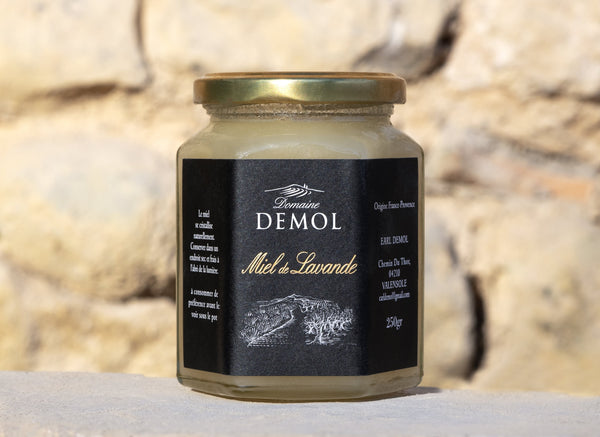 Pot de miel de lavande 250 g du Domaine Demol posé sur un mur de pierre sèche provençal