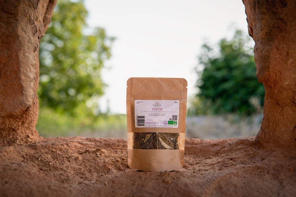 Sachet de thym BIO du Domaine Demol posé en extérieur, devant les cultures du domaine